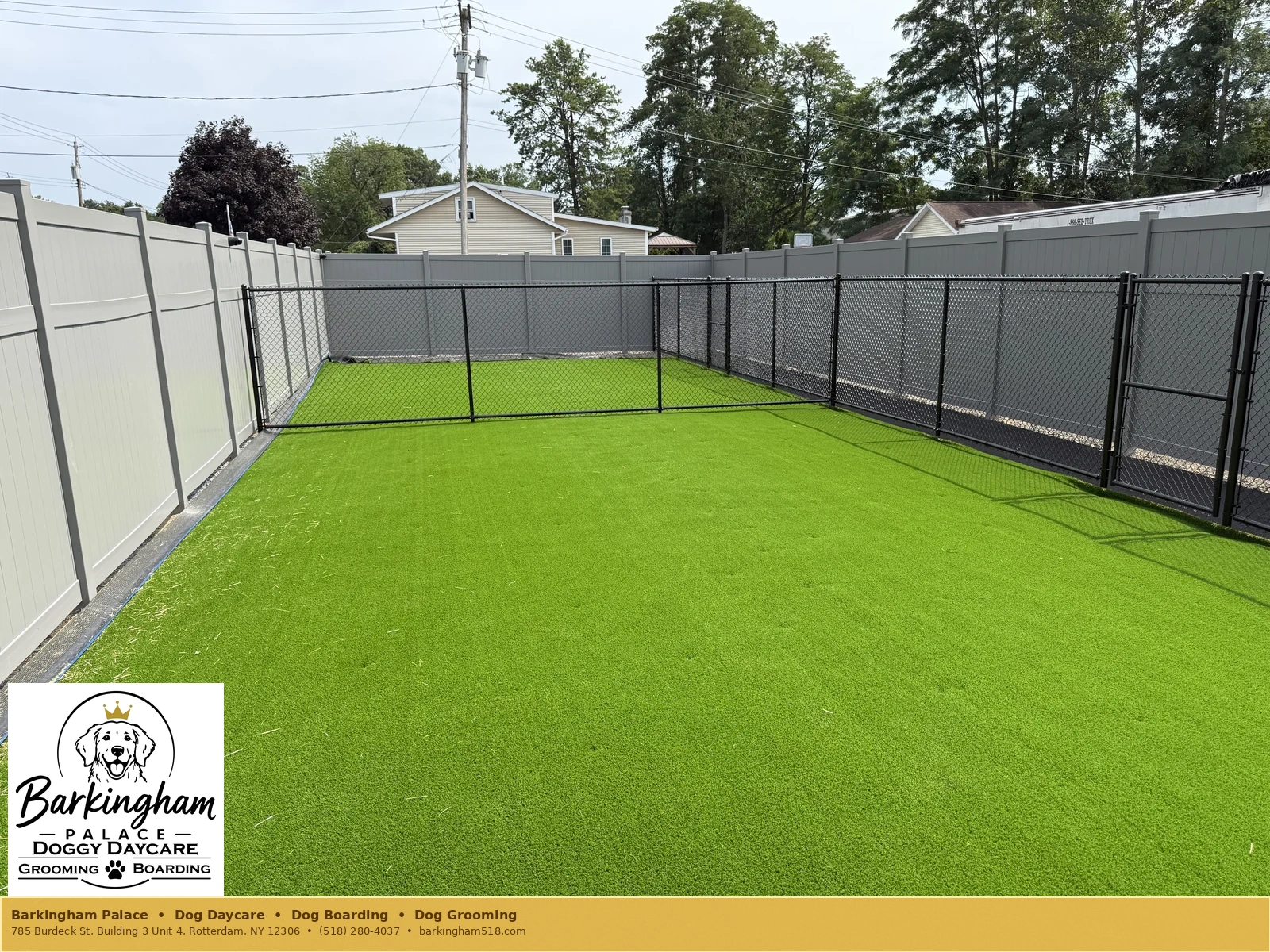 Wide fenced outdoor turf play yard at Barkingham Palace in Rotterdam, NY