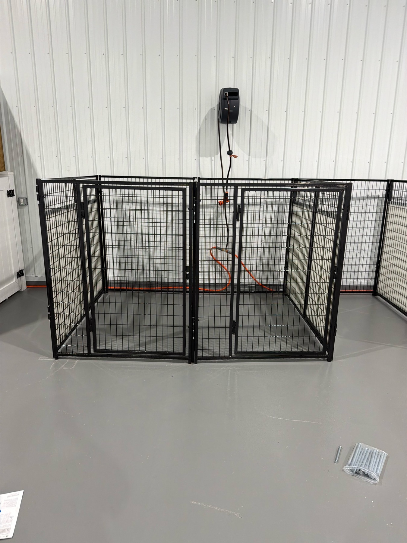 Overnight dog boarding kennel arrangement with two adjoining black metal sleeping suites at Barkingham Palace in Rotterdam, NY